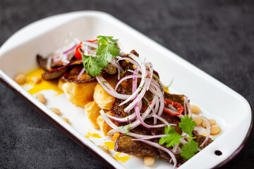 Dry meat, a typical Peruvian dish, accompanied by yuccas and onion sarsa.
