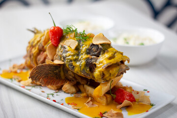 Crispy dorado fish, accompanied by fried yuccas with sauce.
