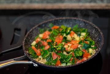 Cooking vegetables with eggs and arepas