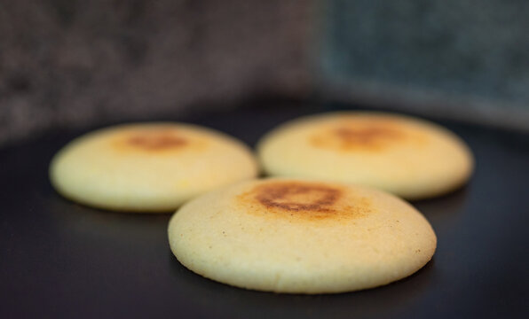 Venezuelan arepas cooking on hot flat pan