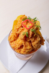 Spicy tiger milk accompanied by pork rinds.