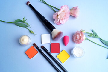 Obraz na płótnie Canvas the makeup kit awaits its use surrounded by beautiful flowers