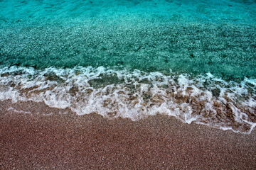 Blue sea wave on a pebble beach.