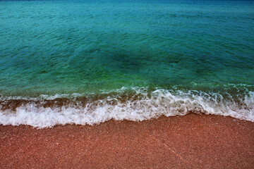 Blue sea wave on a pebble beach.