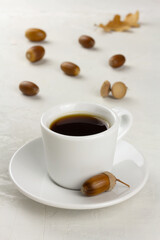Obraz na płótnie Canvas Acorn coffee in a white cup and some acorns. Healthy no caffeine beverage