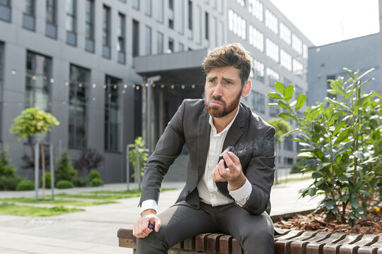 Male businessman smoking cigarette in the air near the office relieves stress after a hard day's work, tired reworked depressed