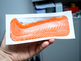 POV male hand holding delicious fresh Salmon sashimi quality salmon bio organic loin skin and boneless - premium food made in Norway