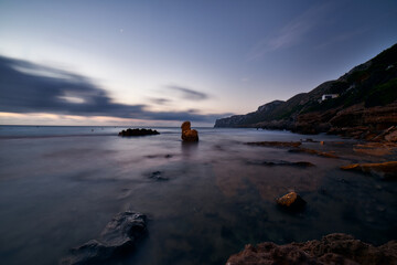 Twilight at the touristic beach Las Rotas in Denia,  Spain. The sea water is quiet and calm. It's a very visited beach at the marine reserve of San Antonio Cape in Alicante