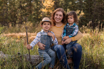 Fototapeta premium Parent and children sitting on a tree stump in a park