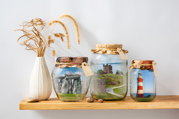 Surrealistic landscapes of England, Scotland in glass jars on shelf, travel memories, stay at home