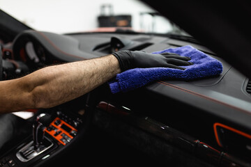 A man cleaning car interior, car detailing (or valeting) concept. Selective focus.