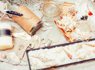 Fototapeta a lot of sea theme in mess like shells, candles, perfume, girl stuff on linen, pretty textured post card view vintage close up obraz