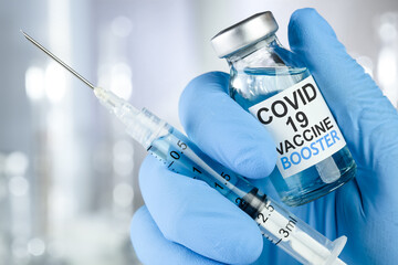 Hand in blue medical gloves holding a syringe and vaccine vial with Covid 19 Vaccine Booster text, for Coronavirus booster shot. - obrazy, fototapety, plakaty