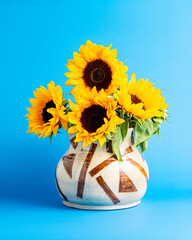 Minimalist modern poster style bouquet of sunflowers on blue background, still life, studio shot