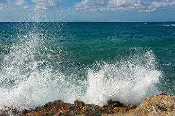 landscape of stormy Mediterranean sea with blue sky and white clouds and white sea foam off the coast of Turkey, Avsalar, Alanya during a storm in autumn