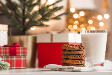 Merry Christmas 2022. Beautiful background with chocolate chip cookies and a glass of milk for Santa Claus. Celebrating the winter New Year holidays. The concept of the beginning of the year.