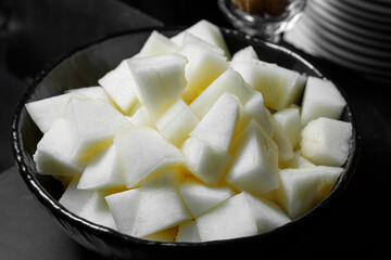 Slices of chopped melon are stacked in a plate.