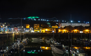 Fototapeta na wymiar Marina with yacht and night city lights in the background, Saint Helier, bailiwick of Jersey, Channel Islands