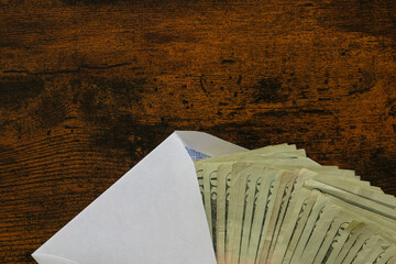 top view and close up of cash money in envelope on wood table, concept to financial about cash.
