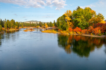 Large boulders along Spokane River as fall leaves turn colors at Autumn at Islands Trailhead along the Centennial Trail in Spokane, Washington, USA