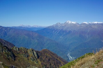 The peaks of the Caucasus mountains covered with snow in the area of the city of Sochi. Russia