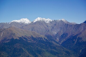 The peaks of the Caucasus mountains covered with snow in the area of the city of Sochi. Russia