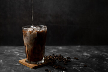 Iced coffee and milk on dark table