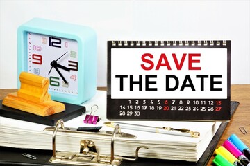 Save the date. The inscription in the planning calendar, against the background of the clock reminders of future affairs.