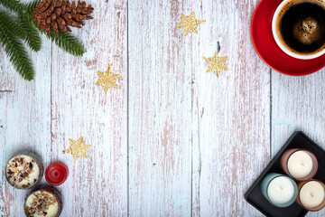 Top view of Christmas ornaments and a cup of coffee on wooden background.