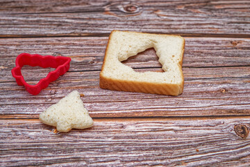 Christmas background, Christmas concept. Slice of bread cut into the shape of a christmas tree on wooden table.