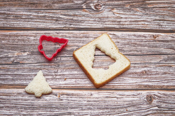 Christmas background, Christmas concept. Slice of bread cut into the shape of a christmas tree on wooden table.