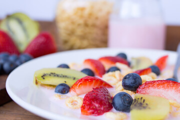 plate with yogurt, cereals, strawberries, blueberries and kiwi - macro