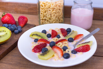 plate with yogurt, cereals, strawberries, blueberries and kiwi