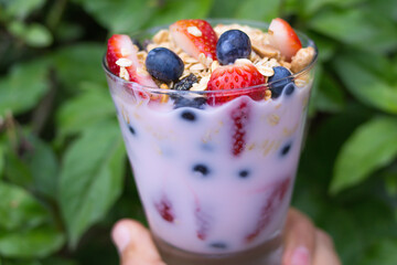 glass with yogurt, cereals, strawberries and blueberries