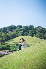 Fototapeta na wymiar 公園を散策するカメラ女子