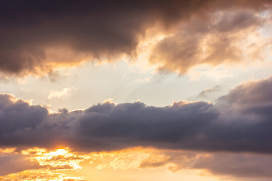 The sky at sundown, and thunderclouds. Sunlight streaming through the clouds. Atmospheric photo.