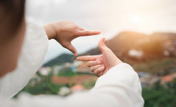 Close-up Female Hand Standing  And Hands Making Frame Gesture With Sunrise It Signals A Foresight With A Broad Vision Of Planning New Ideas, Vacations, And New Vacation Ideas.