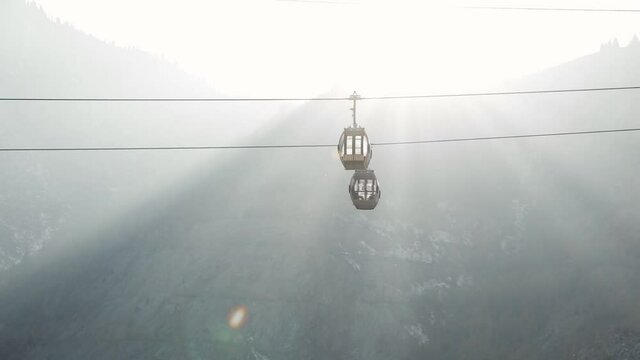 Cable car in silhouette the mountains sunset background