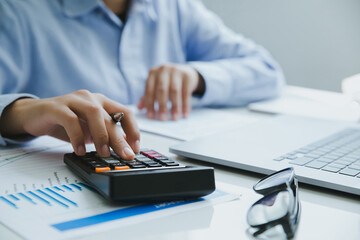 Close up of Man hand holding pen working on calculator to calculate business data. accountancy...