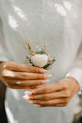 bride holding flower corsage in her hand during her wedding day