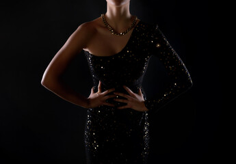 Model wears an elegan black and gold evening dress