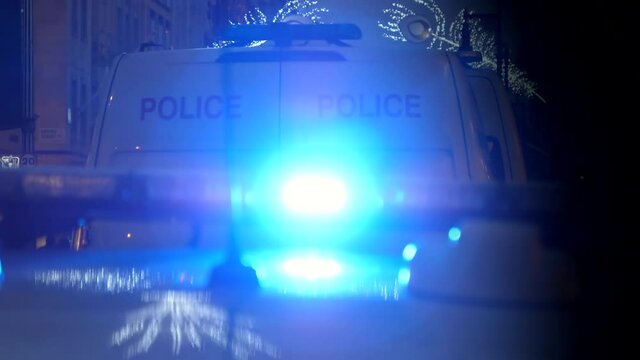 Emergency lights flashing on police car and van in the city at night
