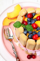 Tiramisu with peach, blueberry and cranberry on wooden background
