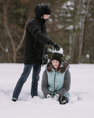 Fototapeta na wymiar Happy couple teenagers having fun playing in snow in winter