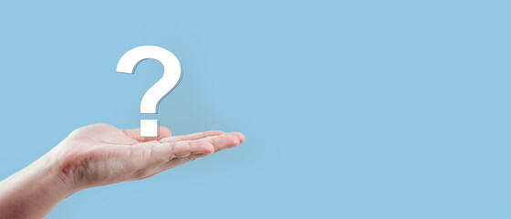Man hand holding question mark icon on blue background.Banner with copy space