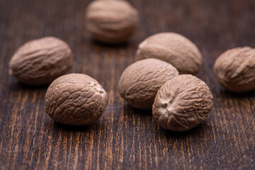 Nutmegs on a wooden brown background. Close-up, studio shot.