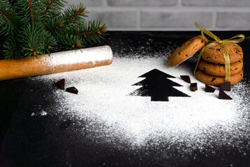 tree made of flour on a black background. Preparing for Christmas