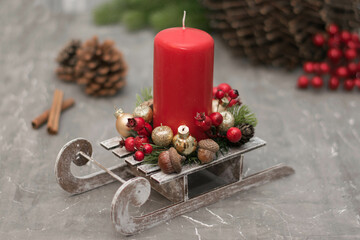 Christmas composition with candle in small sleigh.