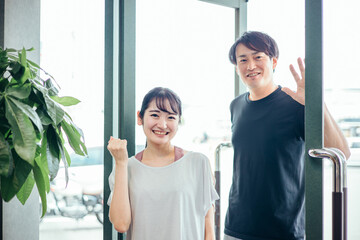スポーツジムに来た男女（ガッツポーズ）
