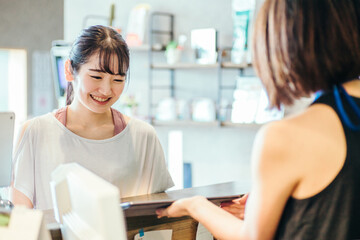 スポーツジムでタブレットを見る女性

